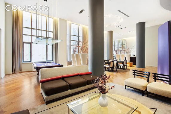 Large indoor space with a pool table, seating area, and dining table.