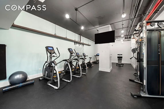 Indoor gym with exercise equipment including treadmills and elliptical machines.