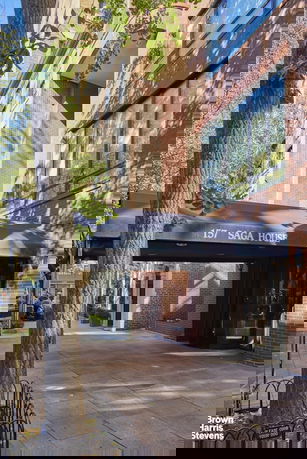 Front view of a multi-story brick building with glass windows.