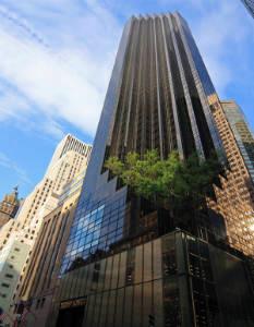 Front view of a tall skyscraper with reflective glass windows.