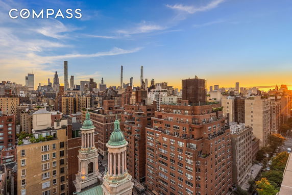 Panoramic view of a cityscape with numerous tall buildings at sunset.