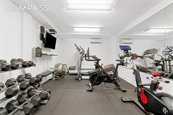 Indoor gym area with exercise equipment and mirrors.