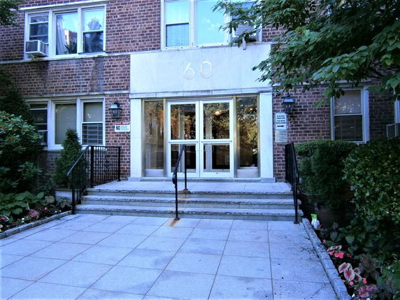 Front view of a multi-story brick building with entrance steps.