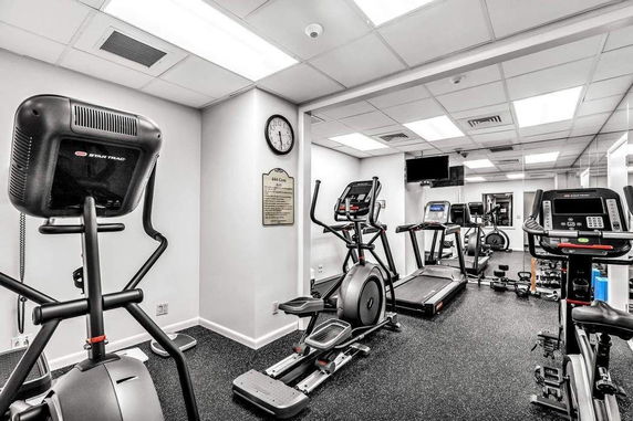 Interior view of a gym with exercise equipment including treadmills and ellipticals.