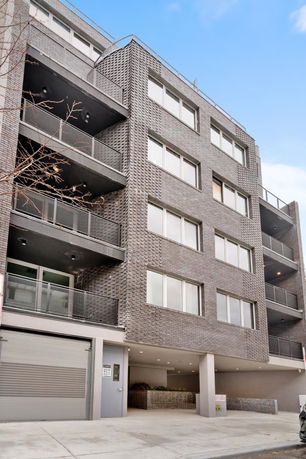 Front view of a multi-story residential building with balconies.