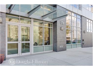 Front view of a modern building entrance with glass doors and windows.