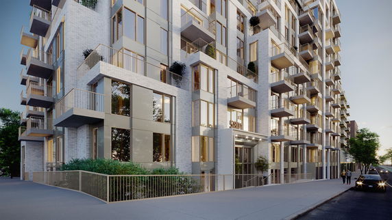 Front view of a modern multi-story apartment building with multiple balconies.