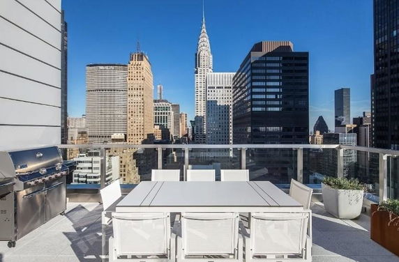 Rooftop area with dining table and skyline view.