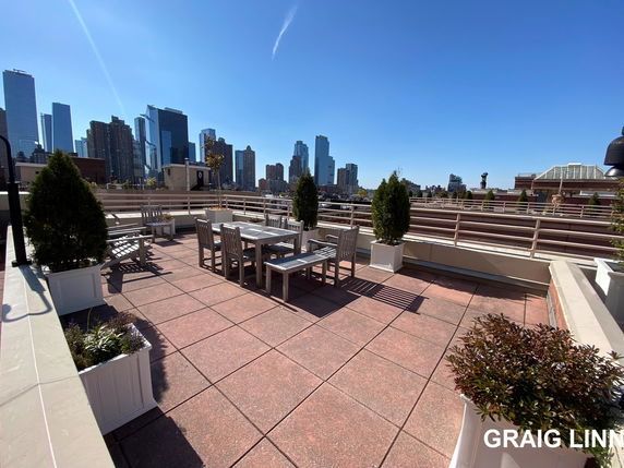 Rooftop with seating area and view of city skyline.