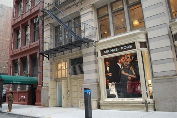 Front view of a building with a Michael Kors store on the ground level.