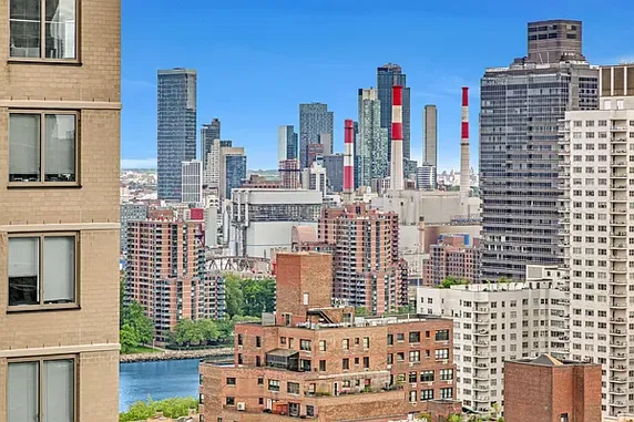 Panoramic view of a cityscape with tall buildings and a river.