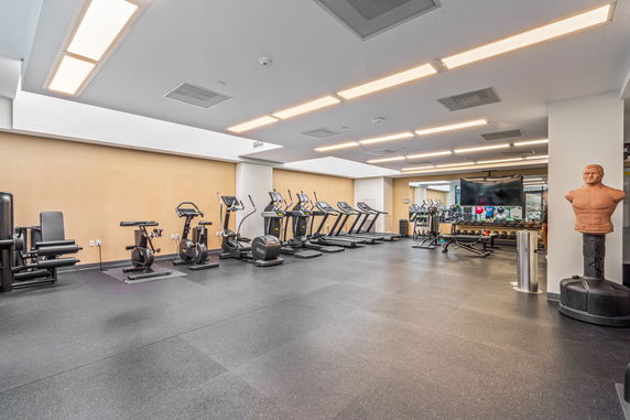Indoor gym area with exercise equipment like treadmills and bikes.