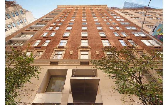 Front view of a tall brick building with multiple windows.