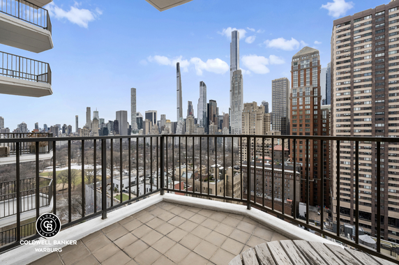 View from a balcony overlooking a cityscape with tall buildings.
