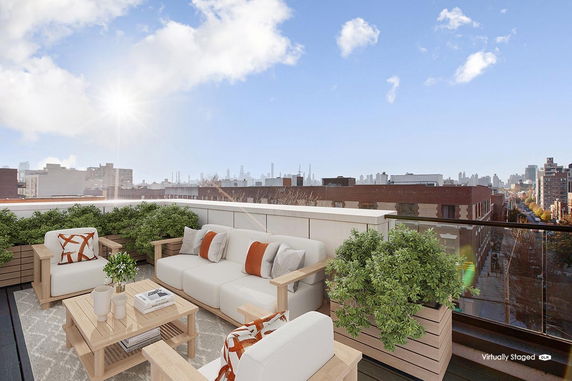Rooftop with seating area and city skyline view.