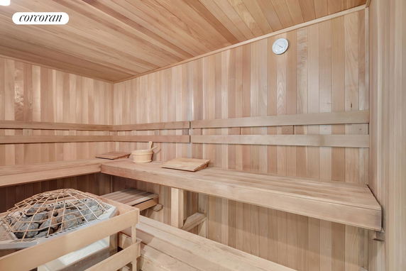 Interior view of a wooden sauna room with benches and a heater.