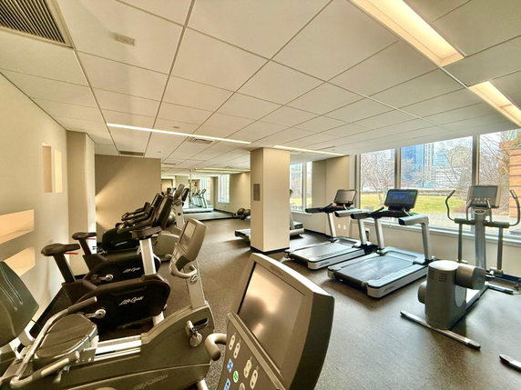 Indoor gym area with exercise equipment and machines.
