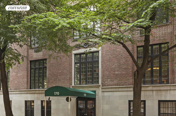 Front view of a brick building with large windows and a green awning.
