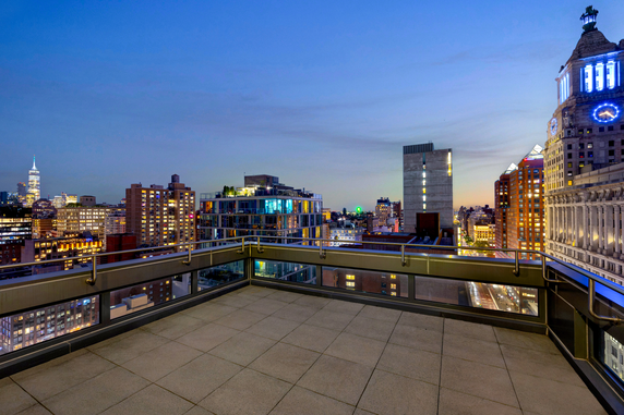 Panoramic view of city buildings from a rooftop at twilight.