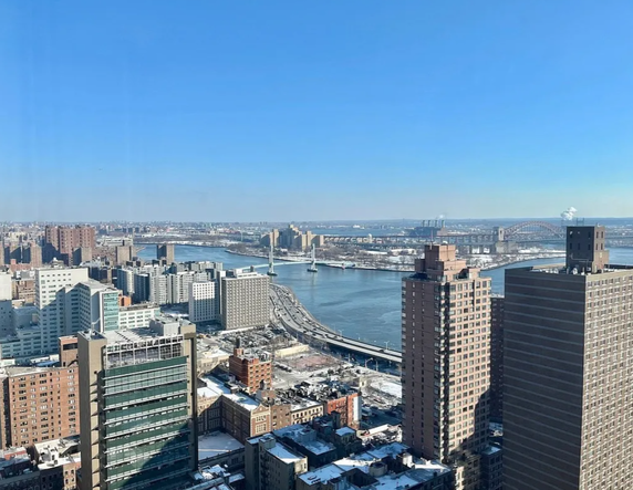 Panoramic view of a cityscape with multiple buildings and a river.