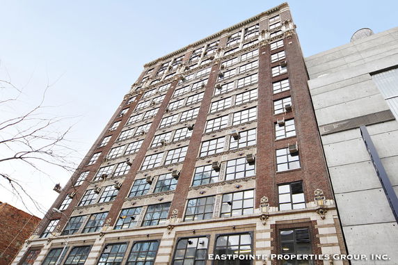 Front view of a multi-story brick building with large windows.