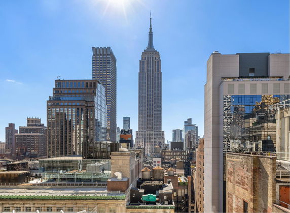 Panoramic view of city skyscrapers under a clear blue sky.