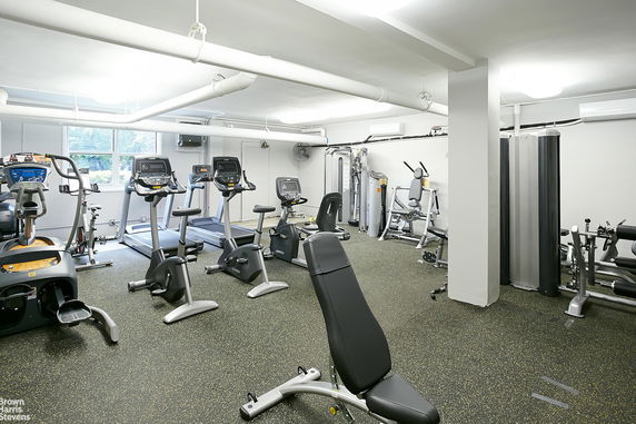 Indoor gym area equipped with various exercise machines and equipment.
