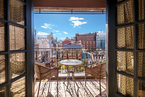 Balcony view of a cityscape with buildings under a clear blue sky.