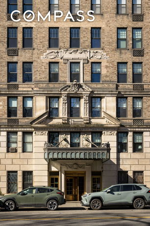 Front view of a multi-story building with decorative façade and arched entrance.