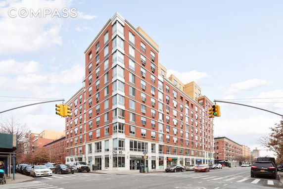 Front view of a multi-story residential building on a street corner.