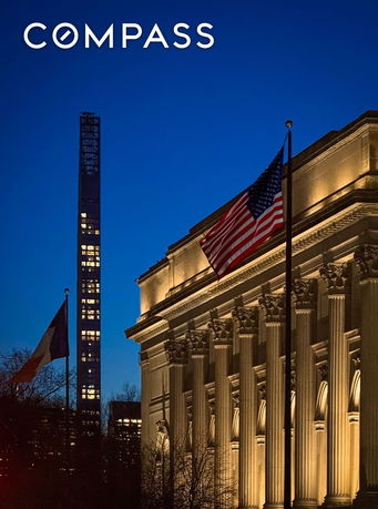 Front view of a grand building with columns and flags under night sky.