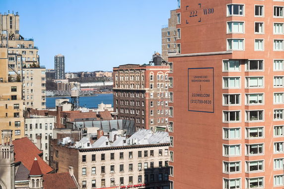 Panoramic view of a cityscape with several buildings and a waterfront in the background.
