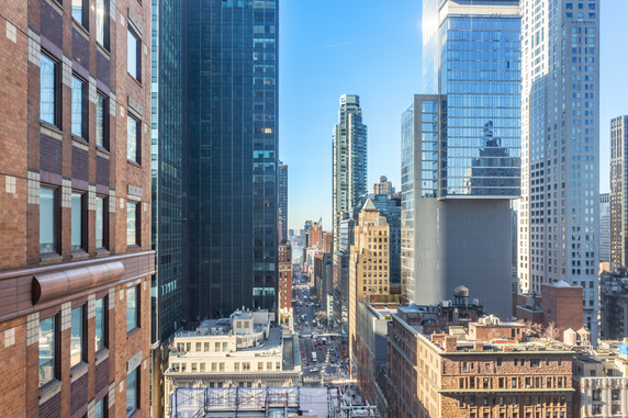 Panoramic view of a cityscape with tall buildings and a street running through them.