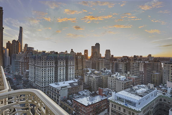 Panoramic view of a city skyline with numerous tall buildings at sunset.