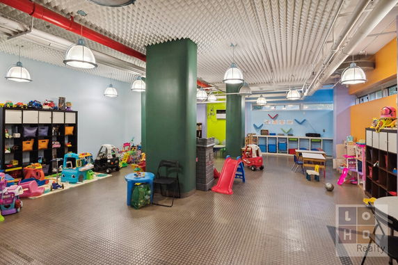 Indoor play area with toys, slides, and storage shelves.