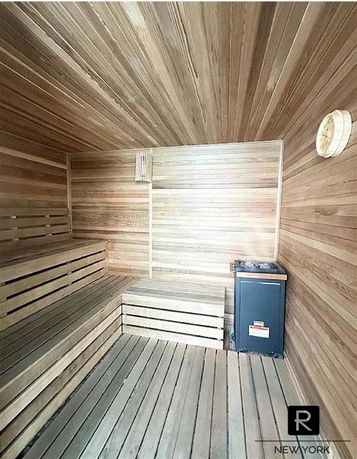 Interior of a wooden sauna room with benches and a heater.