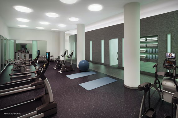 Interior view of a gym with exercise equipment and mats.