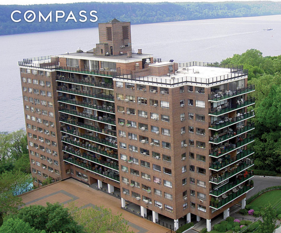 Front view of a multi-story residential building with balconies and large windows.