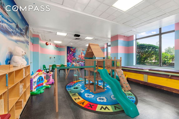 Indoor play area with colorful play equipment and toys.