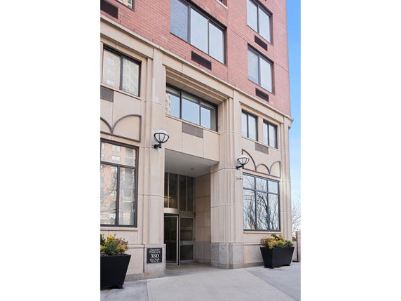 Front entrance of a multi-story building with large windows and decorative trim.