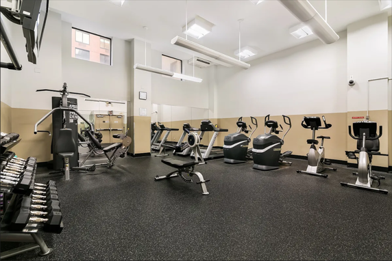 Indoor gym with various exercise equipment including bikes and weights.