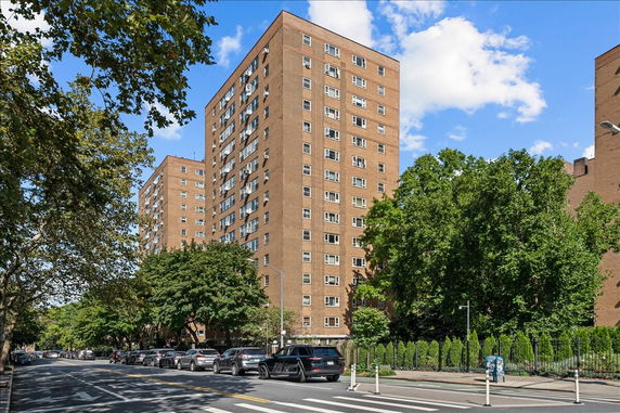 Front view of a multi-story apartment building with numerous windows.