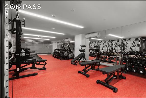 Indoor gym area with fitness equipment including benches, weights, and exercise machines.