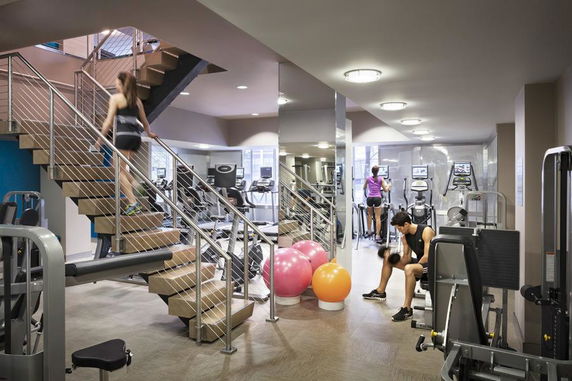 Indoor gym area with exercise equipment and a staircase.