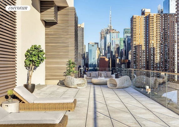 Rooftop terrace with modern outdoor furniture and a view of city skyscrapers.