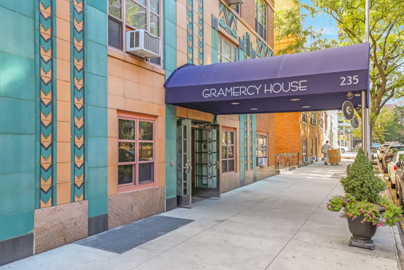 Entrance view of a building with a blue awning labeled 'Gramercy House' and art deco design elements.