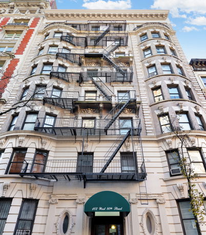 Front view of a multi-story building with fire escapes.