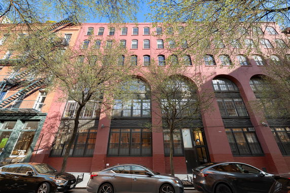 Front view of a multi-story brick building with arched windows.