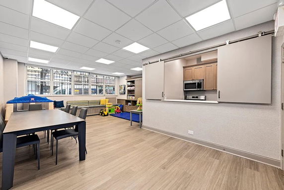 Indoor children play area with tables and toys.