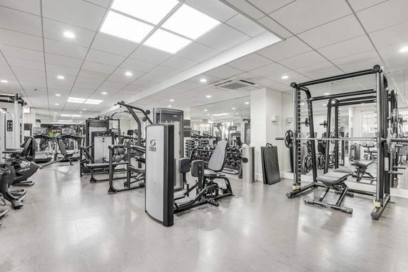 Indoor gym area with various exercise machines and equipment.